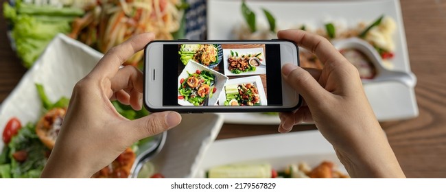 Thai Food. The Hand Is Using A Mobile Phone To Take A Picture Of Food On The Dining Table In The Restaurant. Photography With Mobile Phone Concepts