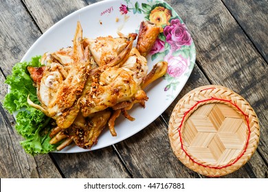 Thai food (KAIYANG) Grilled chicken and sticky rice in wicker basket on wooden background