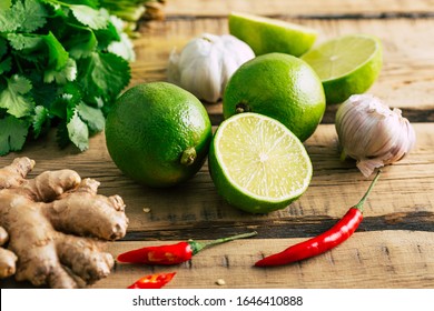 Thai food, lime, ginger, chili pepper, garlic and coriander on a wooden background - Powered by Shutterstock