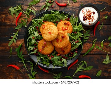 Thai Food Spicy Fish Cakes Served With Pomegranate Seeds And Wild Rocket, Arugula Salad.