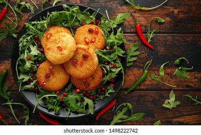 Thai Food Spicy Fish Cakes Served With Pomegranate Seeds And Wild Rocket, Arugula Salad.