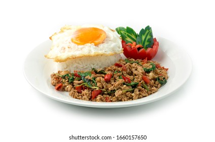 Thai Food Stir-Fried Chicken Spicy And Basil Served With Rice ,Fried Egg And Tomato Cucumber Carved White Plate Side View Isolated On  Background