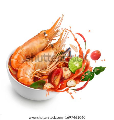 Thai food Tom Yum Kung.Thai hot and spicy soup shrimp in bowl.with Straw Mushroom,lime,Kaffir lime leaves,tomato and chilli. Splash on the air. isolated on white background.