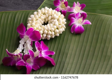 Thai fresh flower garland put on green banana leaves.