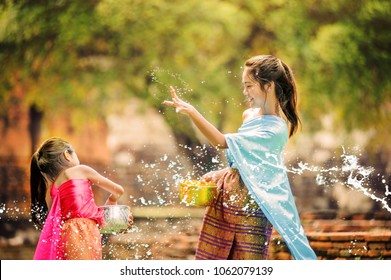 thai girls children playing water in songkran festival with thai period dress at ayutthaya in thailand