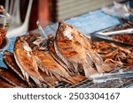 Thai grilled fish, pla pao, for sale from a street food vendor in Chiang Mai. Red Tilapia or Pla Tabtim fish.