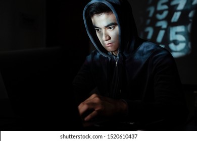 Thai guy in dark room focus on his work in a system.