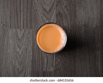 Thai Hot Milk Tea On Black Wooden Table Background In Top View