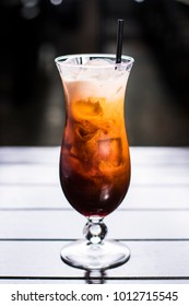 Thai iced tea in tall glass, vertical shot dark background - Shutterstock ID 1012715545