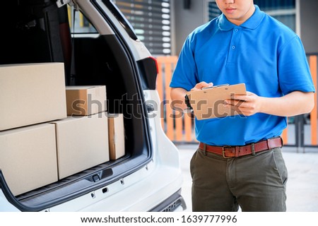 Thai mailman checking parcel and mail boxes for home delivery. Asian online shopping service.