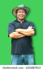 Thai Male, Aged 50-55 Years Close-up Portrait Wearing A Big Cowboy Hat, Smiling Like A Dark-skinned Asian Man On A Green Background.