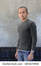 Thai Man In Black Sleeve Skinhead Hairstyle Look Smart On Loft Wall Background