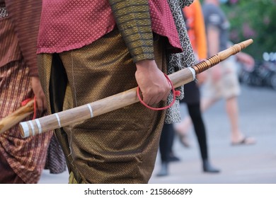 A Thai man is wearing a traditional suit and holding a traditional sword (daab) on a parade