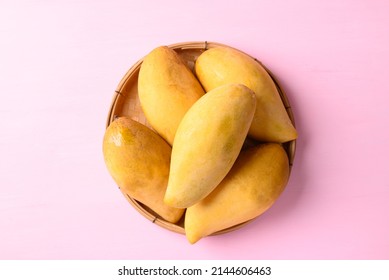 Thai mango (Nam Dok Mai) in basket on pink background, Tropical fruit