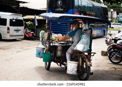 Thai men people sit and riding on motorcycle with tricycle cart for cooking and sale instant and noodles on street road of small alley at Bang Bua Thong city on June 18, 2022 in Nonthaburi, Thailand