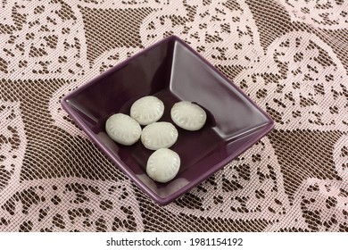 Thai Mint Hard Candy Pieces With Chocolate Filling In Purple Candy Bowl On Pink Lace