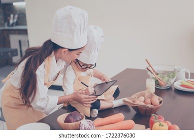 Thai Mom and kid cooking together at home. Online cooking class and e-learning. Family activity Effect from Covid-19 and stop outbreak virus. Lock down and Self-quarantine at home. - Powered by Shutterstock