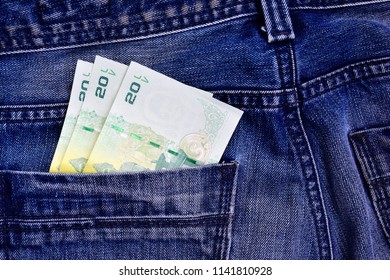 Thai money in the back pocket of jeans. Concept on a trip to Thailand. Concept on a trip to Thailand, shopping for souvenirs