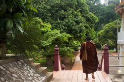 Thai Monk Walking Visit And Go To Respect Praying Buddha Statue At Wat Tham Khuha Sawan In Phatthalung, Thailand.