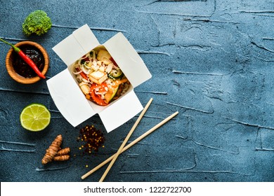 Thai Noodle In Paper Box With Fried Vegetables On Gray Concrete Background. Top View Flat Lay With Copy Space. Street Food To Go