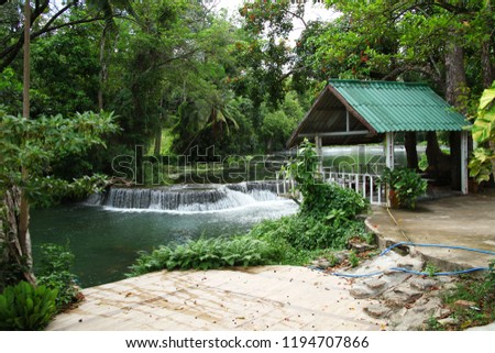Thai pavilion among tree in the forest and waterfall background scene.