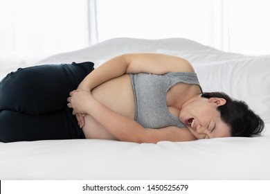 Thai Pluming Woman Sleeps Pain Due To Stomach Pain Giving Birth While She Is 9 Month Pregnant On White Bed In The Bedroom And Window Light Background