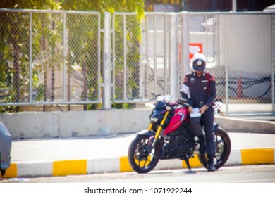 Thai Police : Blurred Photo Traffic Policeman Performs A Duty To Write A Police Order The Car Parked At The Foot Of The Yellow And White. 
 