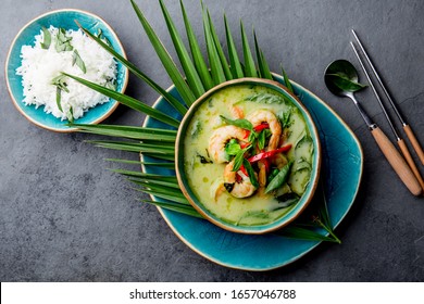 THAI SHRIMPS GREEN CURRY. Thailand tradition green curry soup with shrimps prawns and coconut milk. Green Curry in blue plate on gray background