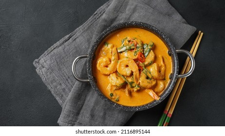 Thai shrimps red curry. Thailand tradition red curry soup with shrimps prawns and coconut milk. Panaeng Curry and dark background.