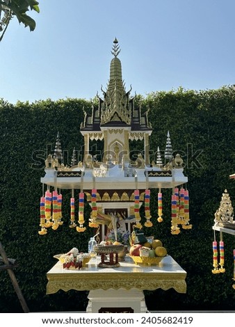 Thai spirit house with food and flower. Spirit house is a shrine to the protective spirit of a place