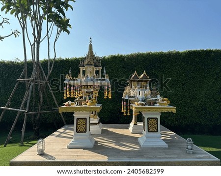 Thai spirit house with food and flower. Spirit house is a shrine to the protective spirit of a place