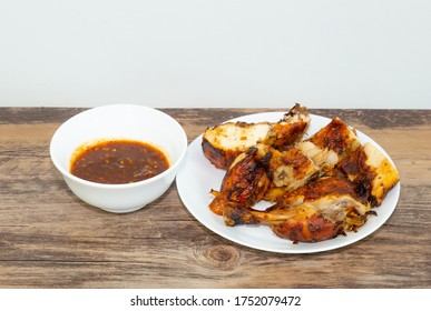 Thai style grilled chicken with chili sauce on the white dish 
