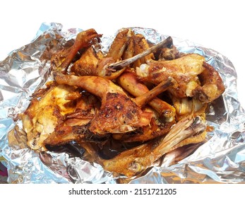 Thai style grilled chicken, chopped whole body on foil paper isolated on white background, normally eat with sticky rice served in many restaurant in Thailand