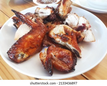 thai style grilled chicken on a wooden dining table