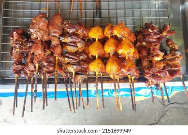 Thai style grilled chicken parts in skewers on stainless steel tray, selling at a shop, street food in Thailand.