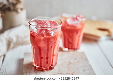 Thai style iced pink milk.Cold sweet drink Red Grenadien Sugar Syrup mix with milk and iced cube in glass, selective focus

