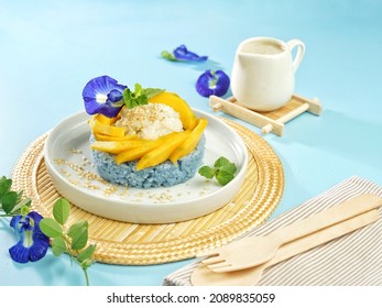 Thai Sweet Blue Sticky Rice with Mango or Khao Nieow Ma Muang. Variation of Mango Sticky Rice with blue sticky rice from blue pea flower. Sprinkle with toasted sesame seeds and coconut milk sauce.