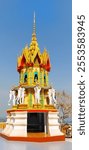 Thai temple featuring vibrant shrine with elephant statues and ornate golden spire, highlighting intricate architectural details