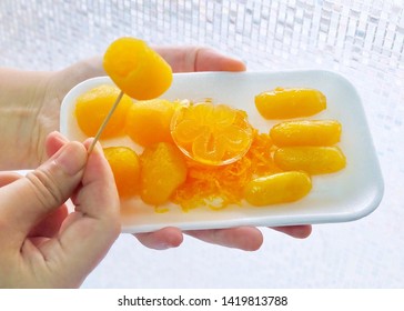 Thai Traditional Dessert, Hand Holding Golden And Sweet Egg Yolks Or Rice Flour And Glutinous Flour Dumplings With Egg Yolks Cooked In Syrup.