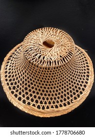 Thai traditional handmade hat made of palm leaves isolated on black background. Hat called in Thai language “Ngob” used for farmer and gardener.