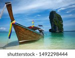 Thai traditional wooden longtail boat and beautiful sand beach at Koh Poda island in Krabi province. Ao Nang, Thailand.