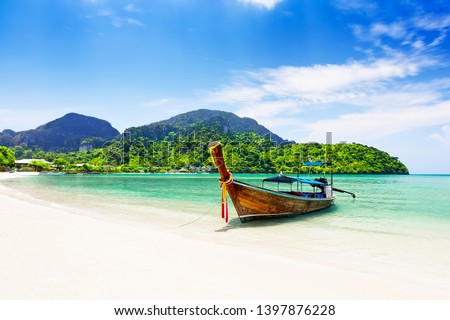Thai traditional wooden longtail boat and beautiful sand beach at Koh Phi Phi island in Krabi province. Ao Nang, Thailand.