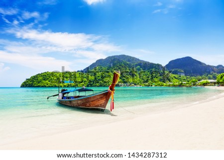 Thai traditional wooden longtail boat and beautiful sand beach at Koh Phi Phi island in Krabi province. Ao Nang, Thailand.