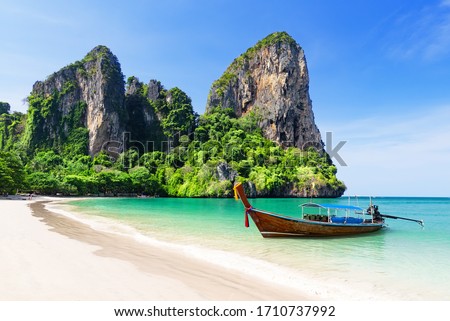 Thai traditional wooden longtail boat and beautiful sand Railay Beach in Krabi province. Ao Nang, Thailand.