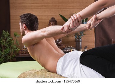 Thai-Frau, die einem Mann Massage macht