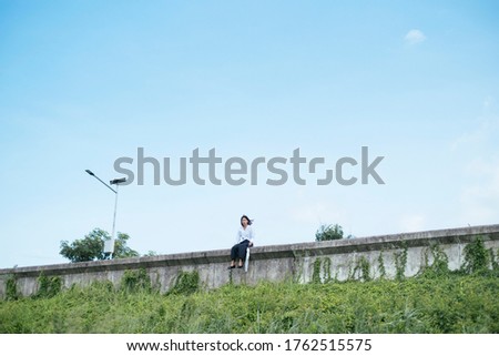 Similar – Young man riding on skate and holding surfboard