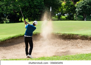 Thai young man golf player in action swing in sand pit during practice before golf tournament at golf course