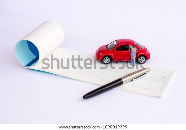  Thailand, April 5, 2018 : Cheque\
book , pen and  red Volk swaken   mini car model isolated on white\
background.  Buy car by cheque payment in\
concept.