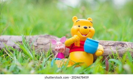 Thailand -August 12, 2021: Winnie The Pooh And Piglet Sit And Eat Honey In The Forest Beside The Logs. Feeling Relax And Fresh.This Figure By Disney Pixar Inc.