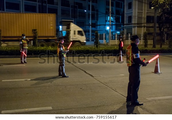 THAILAND,\
BANGKOK, DEC 16 2016, Police officers inspect cars on Bangkok night\
road. Night patrol in town. Vehicle\
inspection.